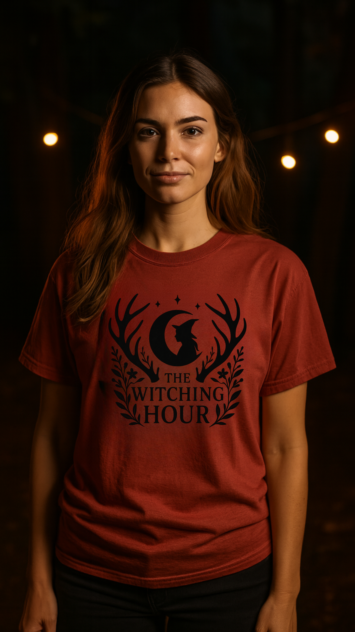 Woman wearing a red t-shirt with 'The Witching Hour' design against a dark background.