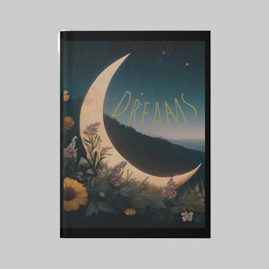 Notebook with a crescent moon and floral design on the cover, featuring the word 'Dreams'.
