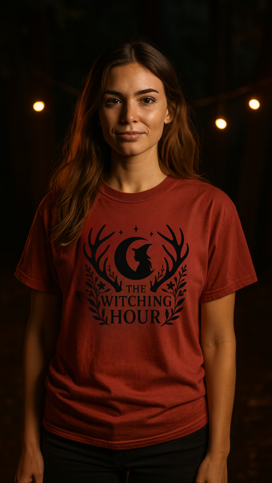 Woman wearing a red t-shirt with 'The Witching Hour' design against a dark background.