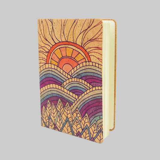 Notebook with a colorful mountain and sun design on a white background